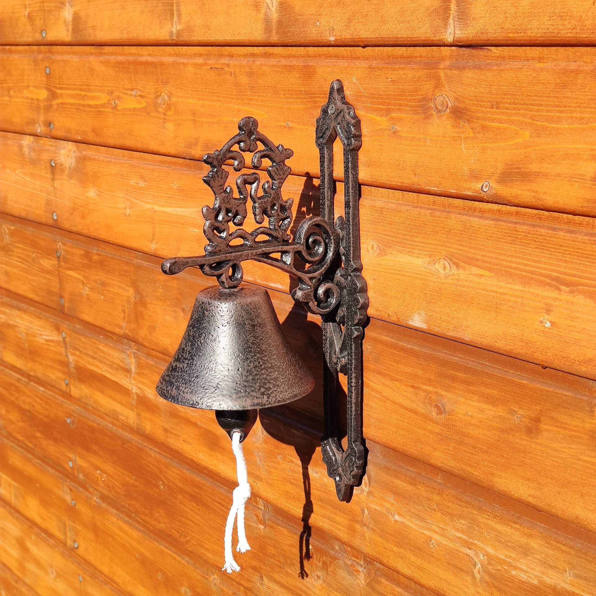 Żeliwny dzwon z ozdobnym emblematem.
